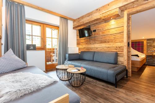 a living room with a couch and a bed at Hotel Sonnberg in Saalbach Hinterglemm
