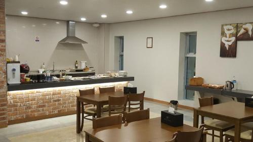 a restaurant with tables and chairs and a kitchen at H Hotel in Ulsan