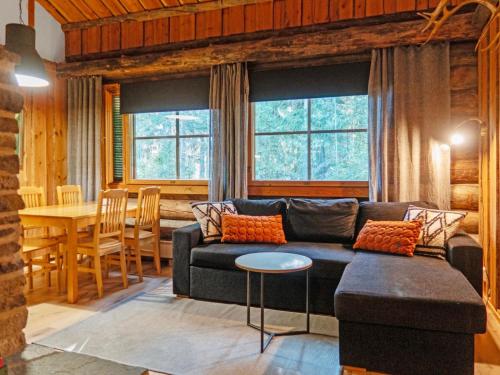 ein Wohnzimmer mit Sofa und Tisch in der Unterkunft Holiday Home Vuokatinportti a 12 by Interhome in Lahdenperä