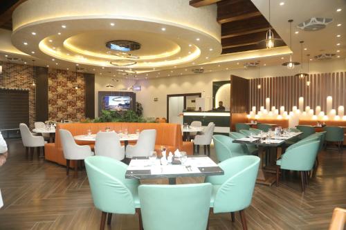a restaurant with tables and chairs and a ceiling at Swarg Hotel in Sāhīwāl