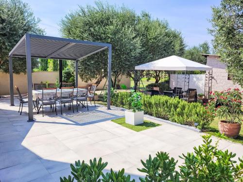 eine Terrasse mit einem Tisch und Stühlen unter einem Baldachin in der Unterkunft Holiday Home Ive by Interhome in Petrcane