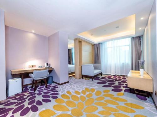 a hotel room with a desk and a bed at Lavande Hotels Xinyu Chengbei Square in Xinyu