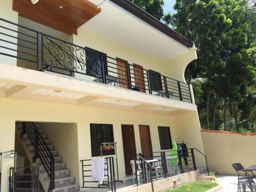 a building with a balcony with stairs and tables at Joaquim's Lodge in Luka