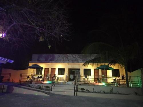 a building with tables and umbrellas at night at Joaquim's Lodge in Luka