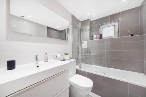 a bathroom with a sink and a toilet and a tub at A beautiful stylish 2 Bedroom Apartment -City of London in London