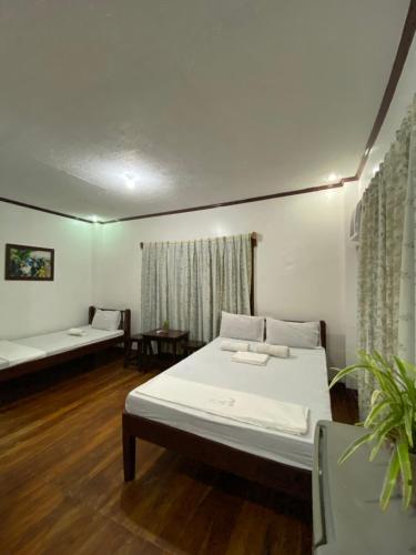a room with two beds and a couch in it at Jala Beach Resort in Loay