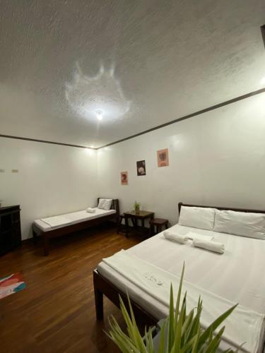 a white room with two beds and a couch at Jala Beach Resort in Loay