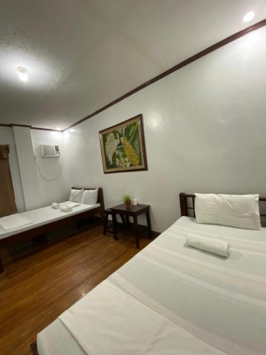 a room with two beds and a bench in it at Jala Beach Resort in Loay
