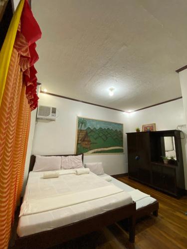 a room with a bed and a television in it at Jala Beach Resort in Loay