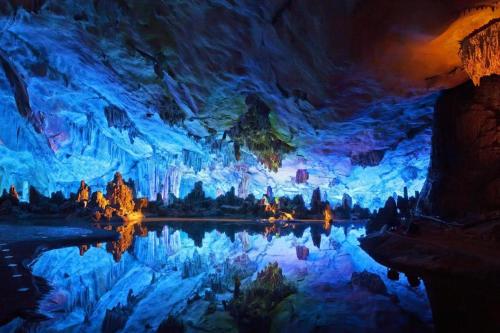 a blue cave with a reflection in the water at JTOUR Inn Guilin Two Rivers and Four Lakes Walmart in Guilin