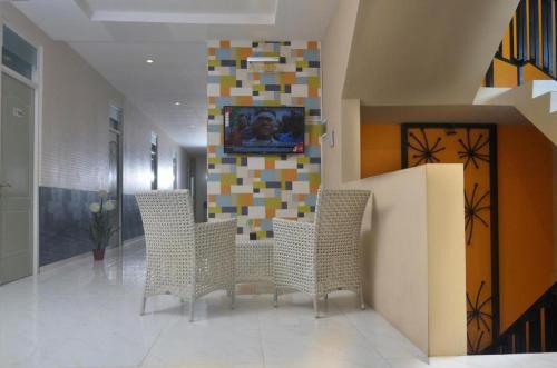 a lobby with chairs and a television on a wall at Hotel Ahava in Magelang