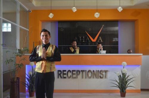 a man standing in front of a reception desk at Hotel Ahava in Magelang