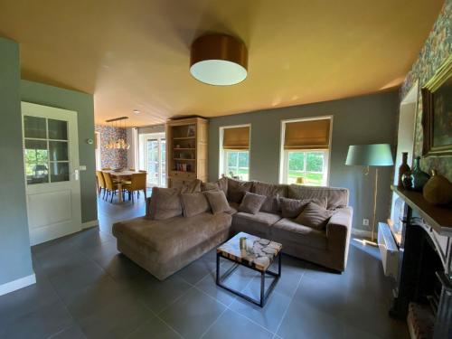 ein Wohnzimmer mit Sofa und Tisch in der Unterkunft Holiday Home Wiringherlant-10 by Interhome in Noordstroe