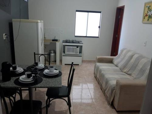 a living room with a couch and a table at Residencial Carvalho Ap 4 in Torto