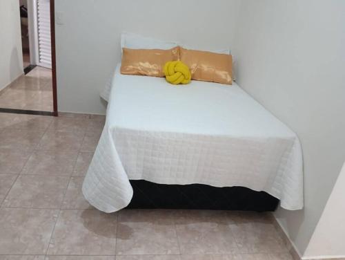 a bed with a yellow banana on top of it at Residencial Carvalho Ap 4 in Torto