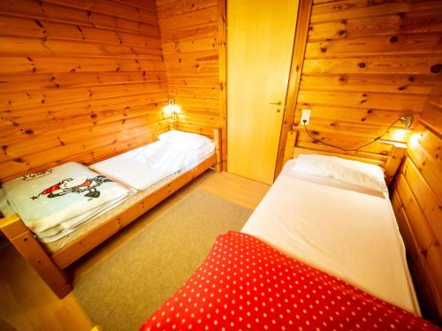 a room with two beds in a wooden room at Chalet Martina by Interhome in Bad Arolsen