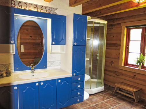 a blue bathroom with a sink and a mirror at Chalet Lindefjeldbu by Interhome in Fossdal