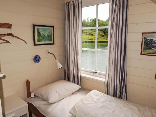 a small bedroom with a window and a bed at Holiday Home Ørviksnes by Interhome in Steinstø
