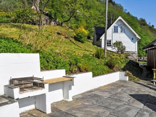 a white retaining wall with a bench in front of a house at Holiday Home Ørviksnes by Interhome in Steinstø