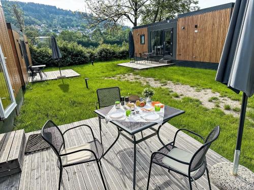 a patio with a table and chairs on a deck at Holiday Home Tiny Haus Sonnenplatz by Interhome in Riedenburg
