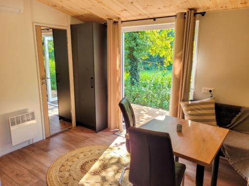 una sala da pranzo con tavolo, sedie e porta scorrevole in vetro di Holiday Home Tiny Haus Soul & Forest by Interhome a Wemding