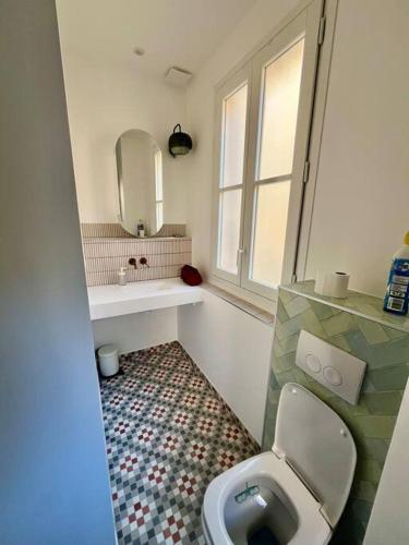 une salle de bain avec toilettes, lavabo et fenêtre dans l'établissement Charmant T3 au cœur de la ville, à Hyères