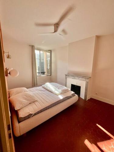 une chambre avec un lit et une cheminée dans l'établissement Charmant T3 au cœur de la ville, à Hyères
