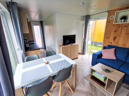 a living room with a table and a blue couch at Holiday Home Tiny Haus Christas Angler-Oase by Interhome in Riedenburg