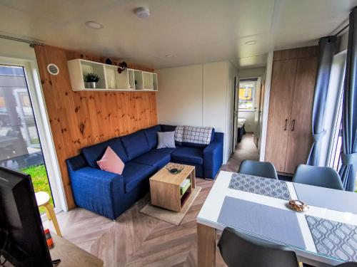 a living room with a blue couch and a table at Holiday Home Tiny Haus Christas Angler-Oase by Interhome in Riedenburg