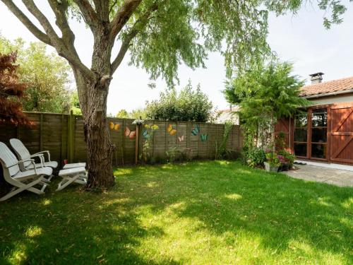 a yard with a tree and a fence at Holiday Home Noordzeepark Zeewind 2-12 by Interhome in Bredene
