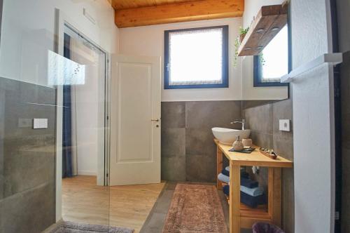 a bathroom with a sink and a glass shower door at Ca' Brazzo Bed Relais in Pontecasale