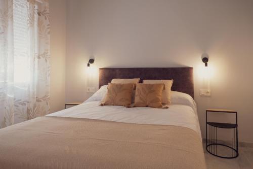 a bedroom with a large white bed with two pillows at Apartamento Urbano Granada in Granada