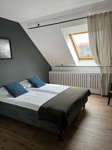 a bedroom with a large bed with blue pillows at UKAS majutus in Saku