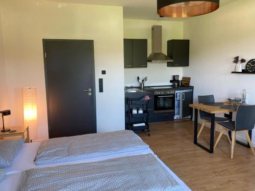 a room with two beds and a kitchen with a table at Appartement Willems in Konz