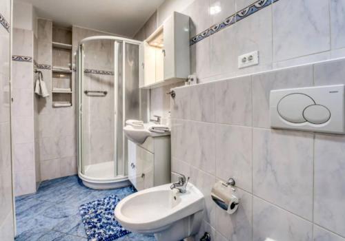 Apartment with sea view في أوباتيا: حمام مع حوض ومرحاض ودش