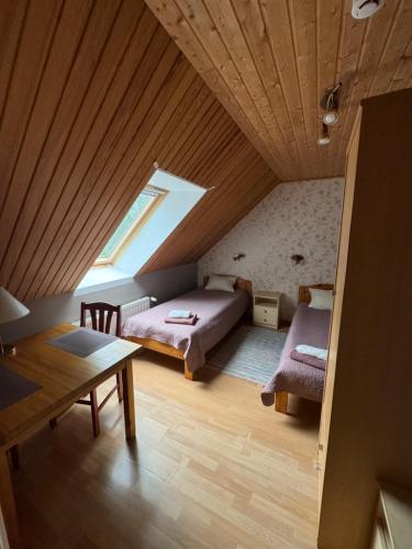 a attic room with a bed and a table at Varese Paik in Osula