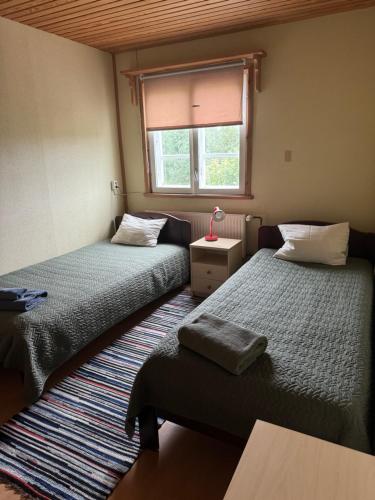 a room with two beds and a window at Varese Paik in Osula