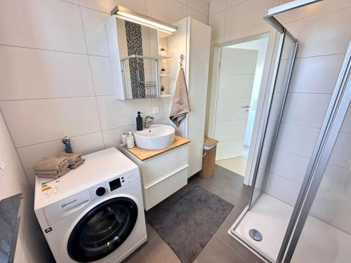 a bathroom with a washing machine and a sink at Privatwohnung Rüsselsheim nähe Hyundai Airport Messe etc in Königstädten