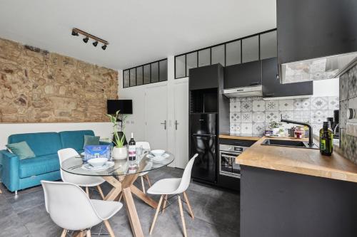 une cuisine et un salon avec une table et des chaises dans l'établissement Lavie Maison I Marais & Historic & Central, à Paris