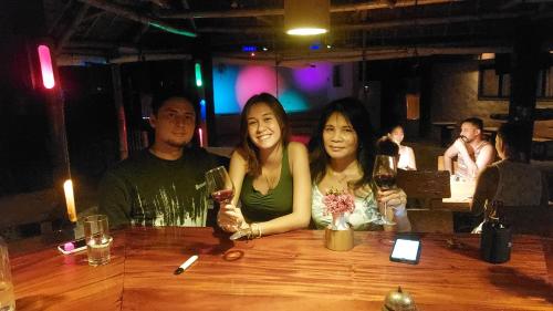 a group of people sitting at a table with wine glasses at Sugar Lounge Lodge in Nauhang