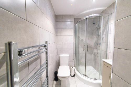a white bathroom with a toilet and a shower at Contemporary 1 Bed Apartment in Blackburn Centre in Blackburn