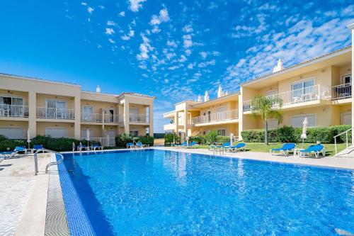 a swimming pool in front of a resort at Albufeira Palm Tree With Pool by Homing in Albufeira