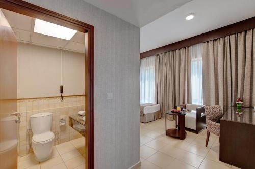 a bathroom with a toilet and a sink at SUHA JBR Hotel Apartments in Dubai