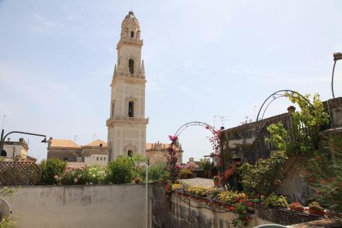 a clock tower in the middle of a city with flowers at Palazzo Rollo in Lecce