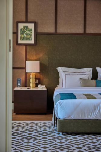 a bedroom with a bed and a table with a lamp at The Stay Boulevard Nisantasi in Istanbul
