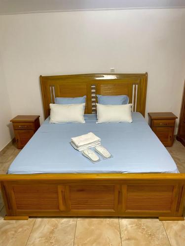 a bed with blue sheets and two towels on it at Appartement Lyanna in Libreville