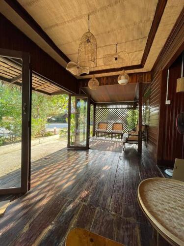 a large living room with a wooden floor and glass doors at Kapas View, Zaki's Residence, Marang, Terengganu in Kampong Ru Lima