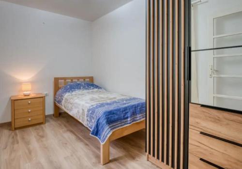 Apartment with sea view في أوباتيا: غرفة نوم مع سرير و كومودينو مع سيد السرير