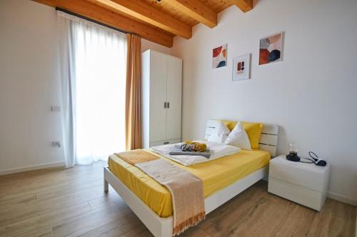 a bedroom with a bed with yellow sheets and a window at Ca' Brazzo Bed Relais in Pontecasale