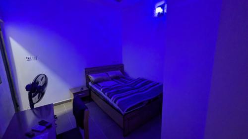 a room with a purple room with a bed in it at Nexcon Apartments in Uyo